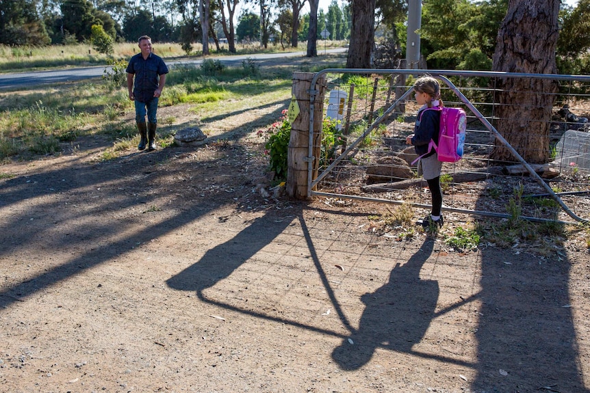 Shane Attwell comes to meet his 6-year-old daughter Charlotte at the front gate before the school bus comes. He does his best to seize small moments with his children in between farm duties