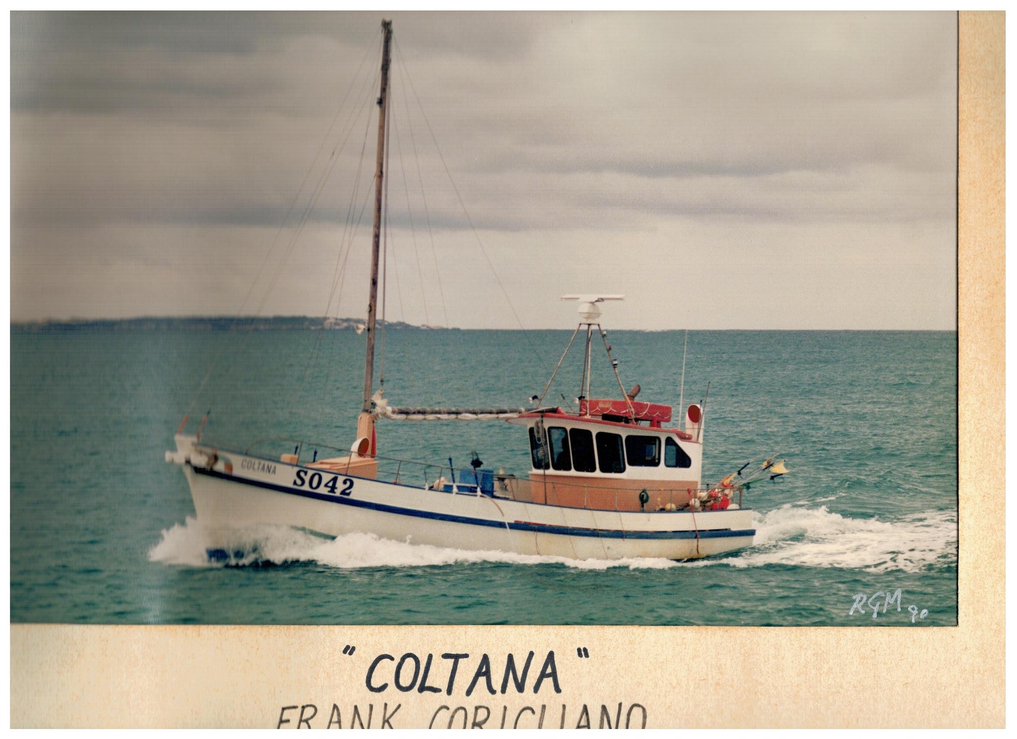 A white and orange timber cray boat in the water at Beachport, South Australia.