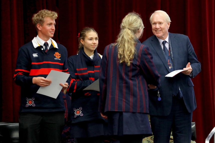 School Barker principal Phillip Heath shakes hands of students as he hands out certificates 