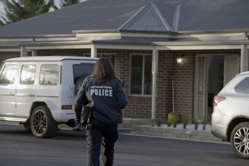 A police officer outside a house.