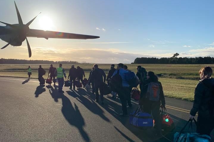 TFS firefighters walk towards RAAF Hercules to fly to NSW, 10 November 2019.