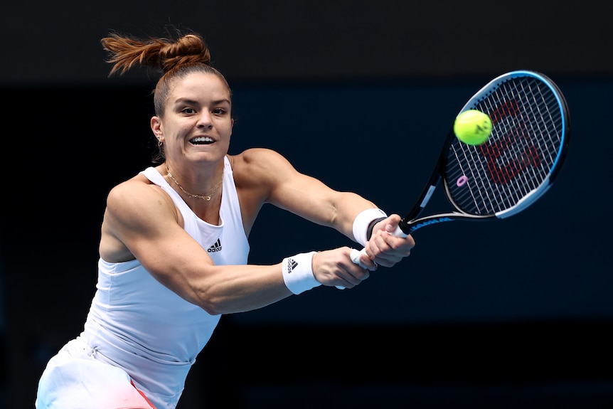 A Greek female tennis player plays a double-handed backhand at the Australian Open.