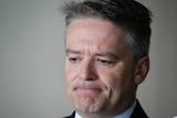 Finance Minister Mathias Cormann looks down and frowns.