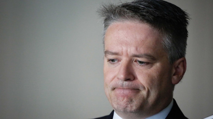 Finance Minister Mathias Cormann looks down and frowns.
