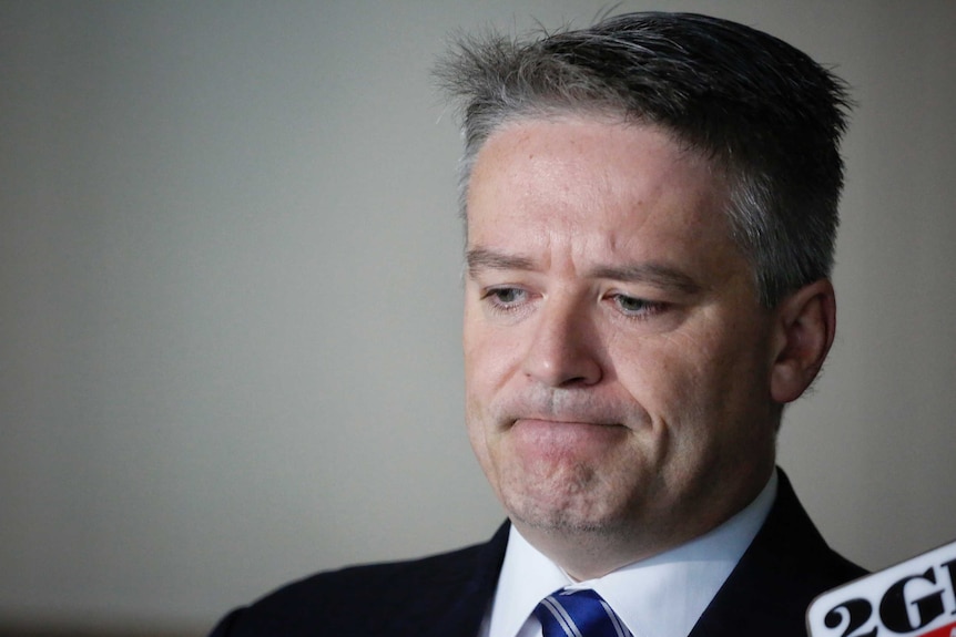 Finance Minister Mathias Cormann looks down and frowns.