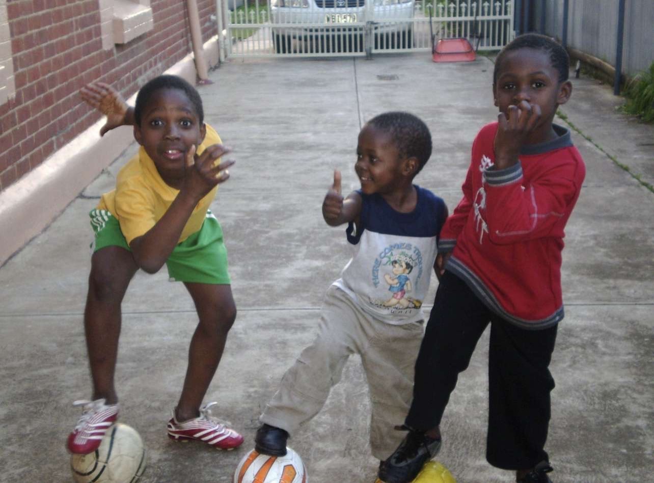 Young brothers play and laugh together in their family driveway