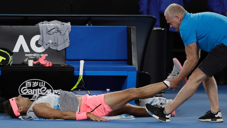 Spain's Rafael Nadal receives treatment from a trainer at the Australian Open.