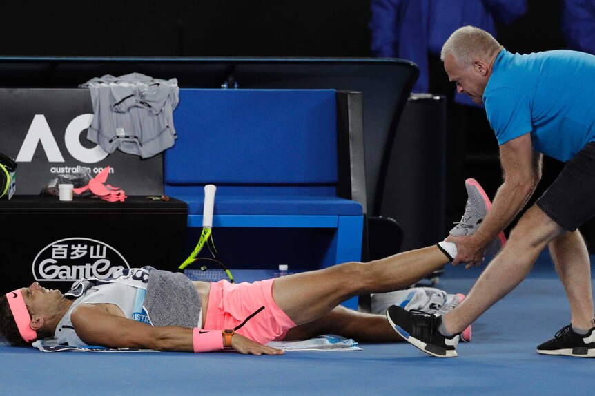 Spain's Rafael Nadal receives treatment from a trainer at the Australian Open.
