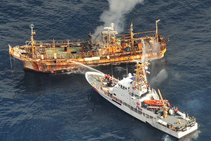The Coast Guard Cutter Anacapa crew douses the adrift Japanese vessel with water after a gunnery exercise.