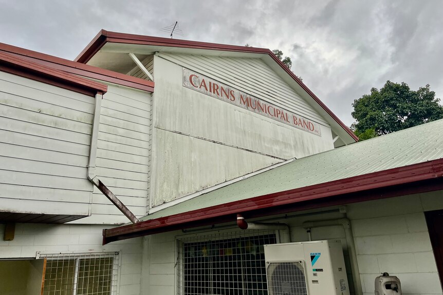 An old building with a sign reading Cairns Municipal Band on the outside.