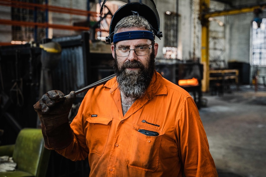 Man in high vis and a mask in workshop