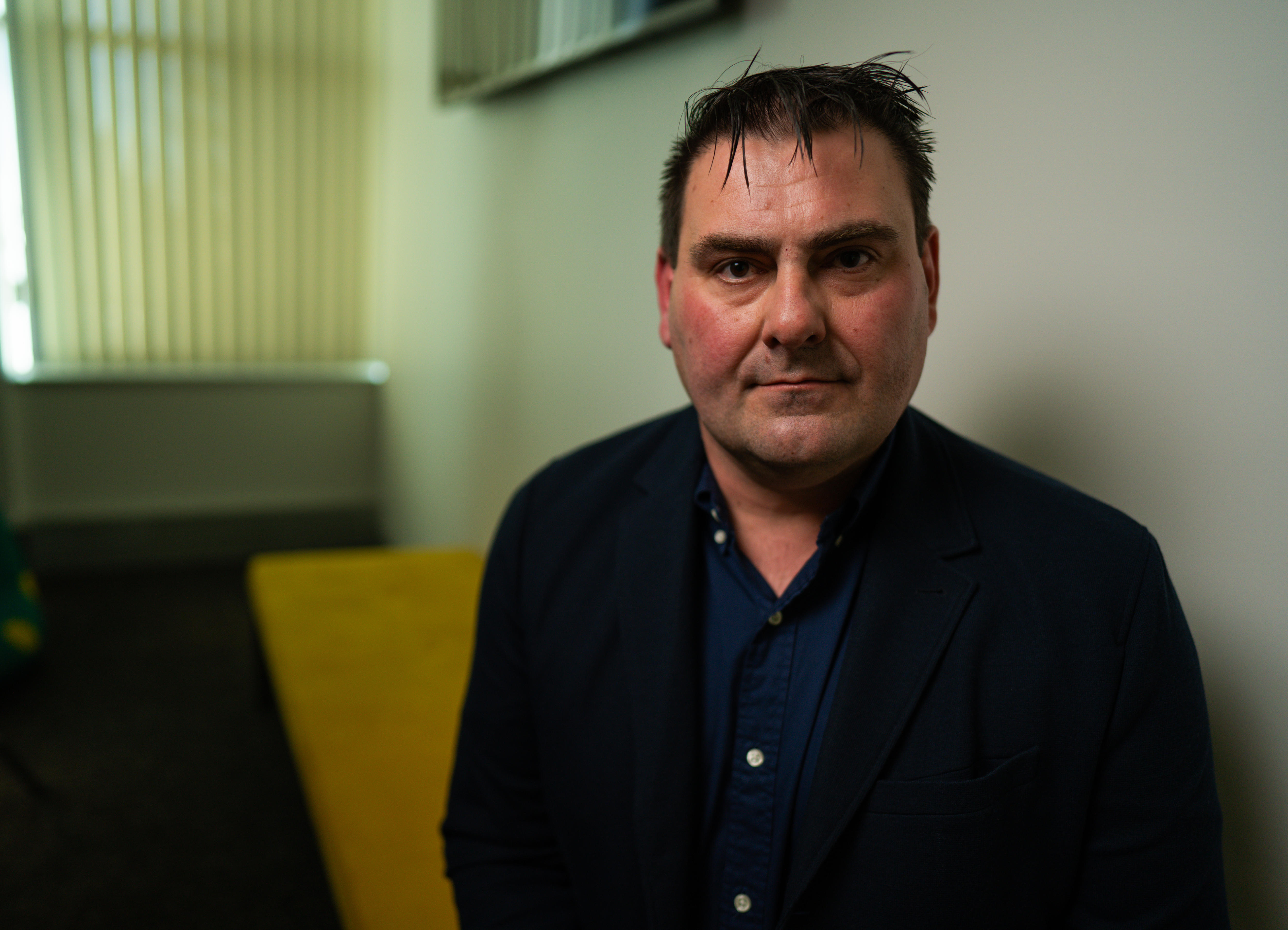 A man in a dark shirt in an office