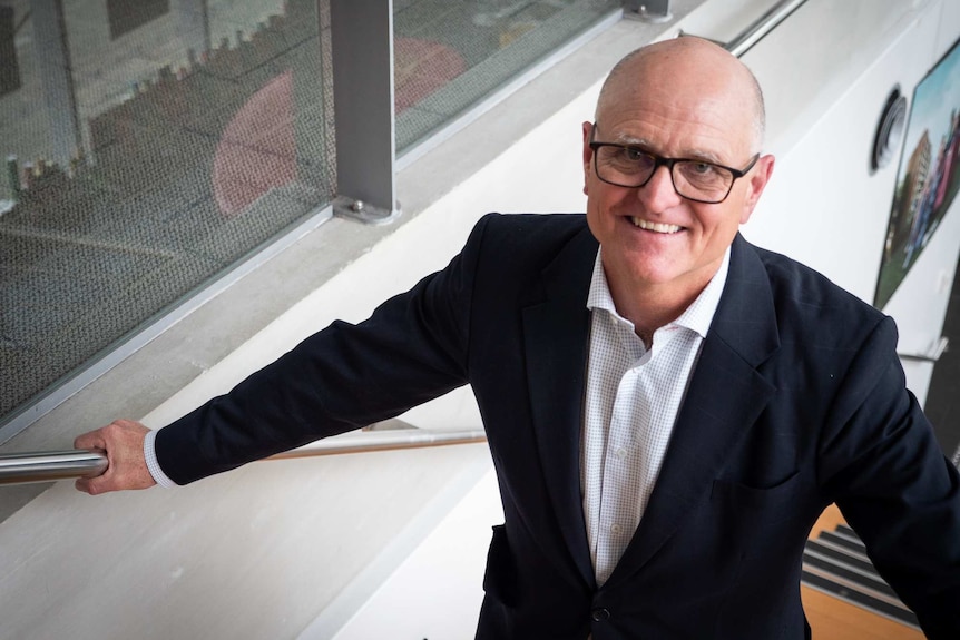 David Andrew, private wealth advisor, stands on staircase