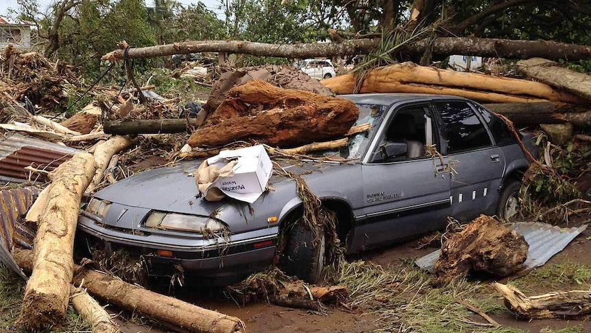 A car is covered by debris in the wake of Cyclone Evan in Samoa.
