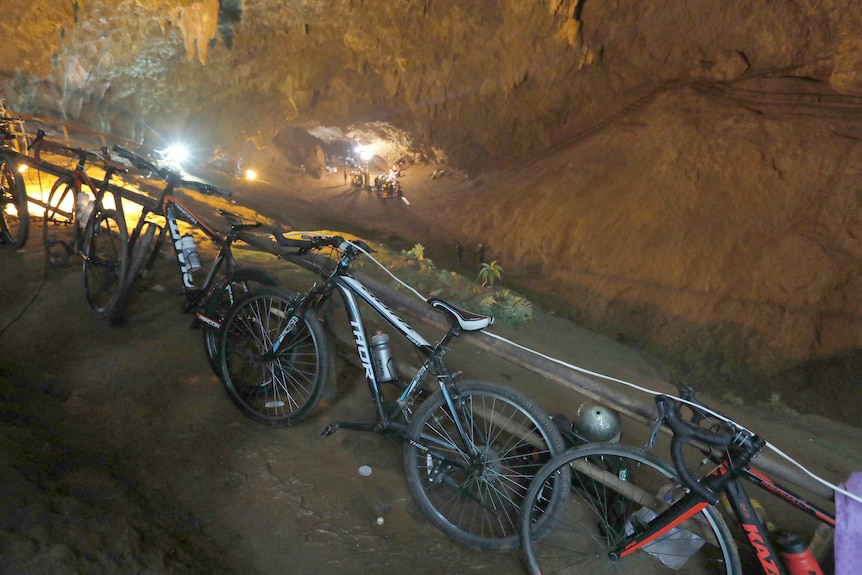 Bicycles left by a group of missing boys lean against a railing at the entrance of a deep cave in Chiang Rai, northern Thailand.
