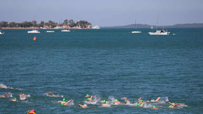 Swimmers in green caps in the ocean