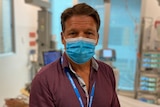 A man with a mask sits in a hospital.