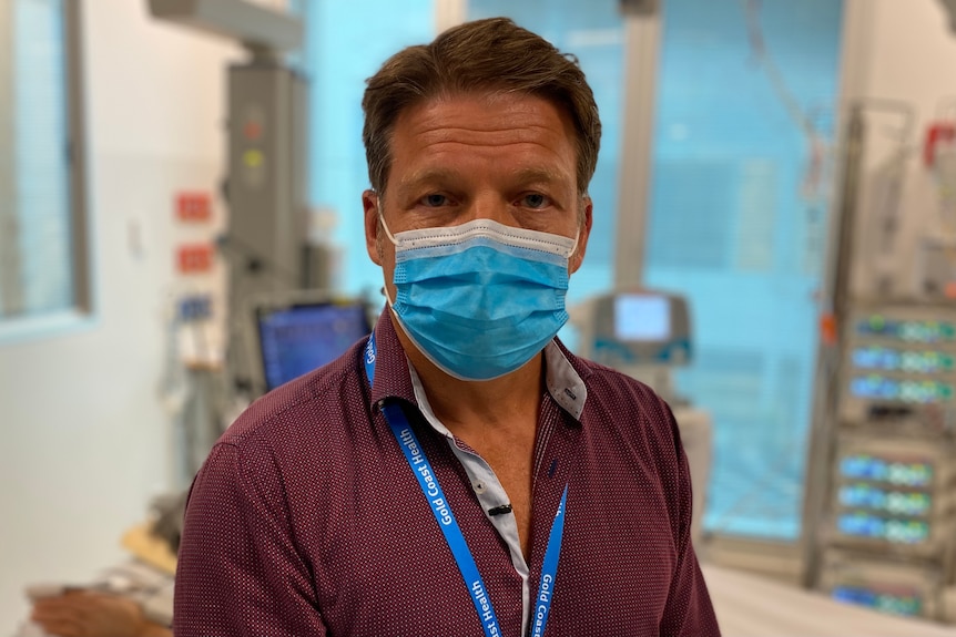A man with a mask sits in a hospital.