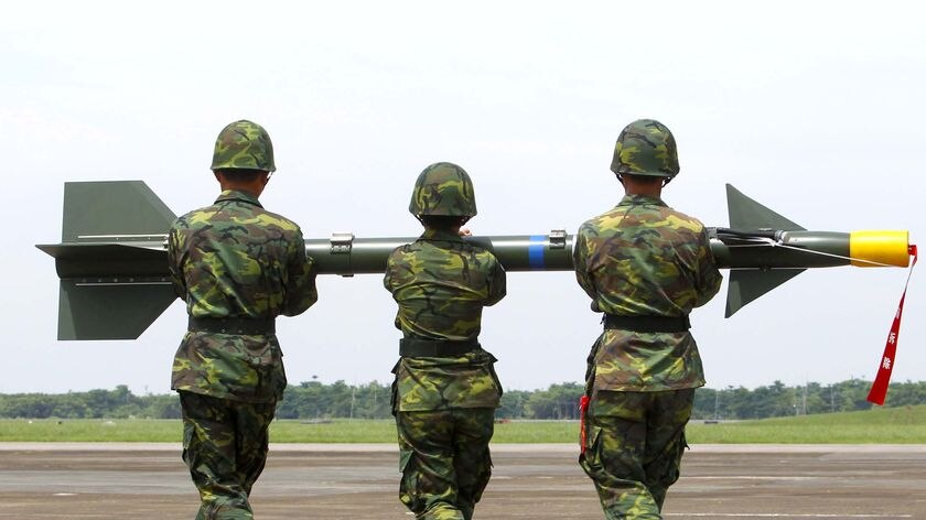 Soldiers carry a surface-to-air missile onto a launcher