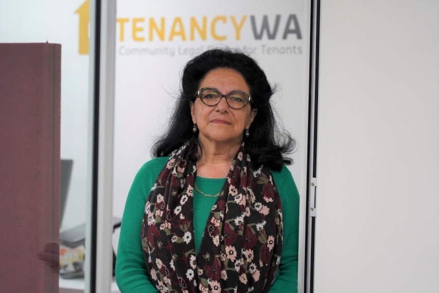 A medium shot of carmen Acosta standing in front of a 'Tenancy WA' sign.