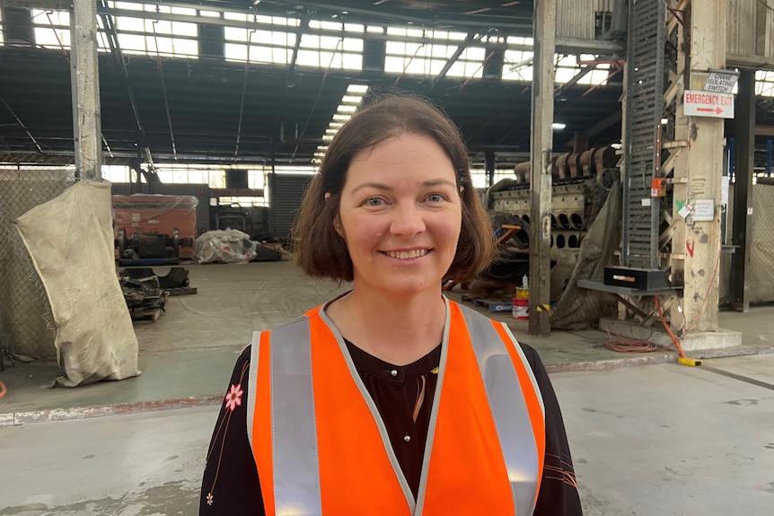 A woman in a hi-vis standing in a factory