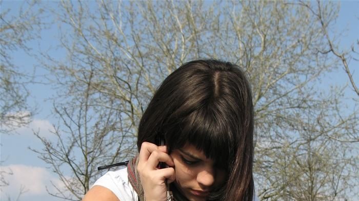 Teenage girl talking on mobile phone in a park