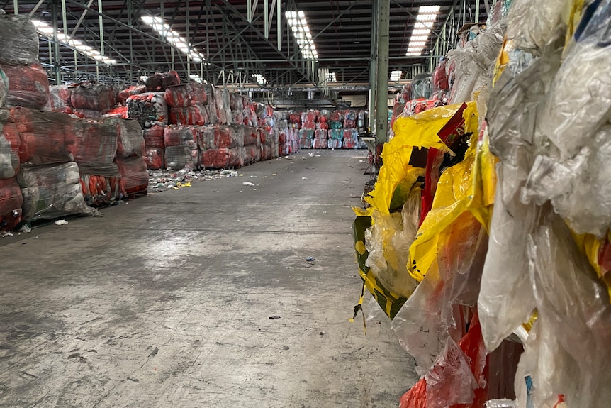 The inside of a warehouse with rows and stacks of soft plastic bundles.