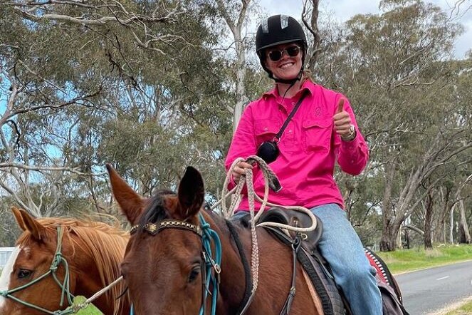 Abigail Wehrung rides on a horse wearing a pink top.