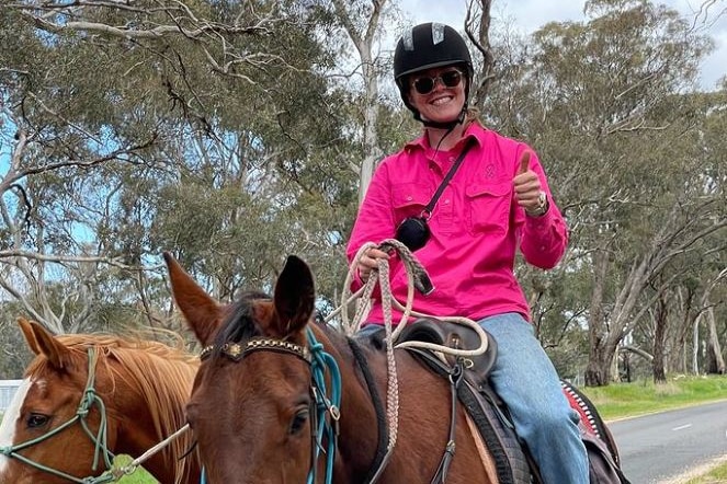 Abigail Wehrung rides on a horse wearing a pink top.