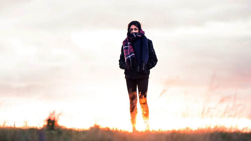 Young woman in exercise clothes and a big scarf outside