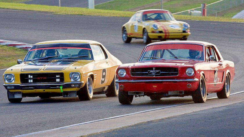 A 1972 Holden Monaro (left) HQ GTS races against a 1964 Ford Mustang in a historic race meeting at Eastern Creek Raceway in Sydney in May 2009.