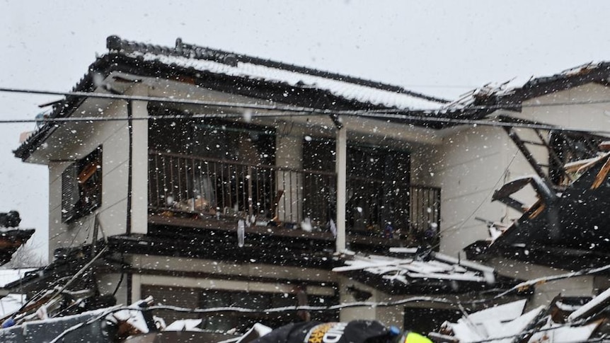 Rescue worker slips in snow in Japan quake rubble