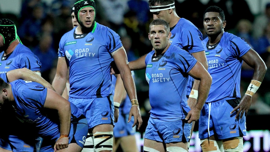 Six Western Force players including Matt hodgson prepare for a scrum wearing blue jerseys and shorts in a Super Rugby match.