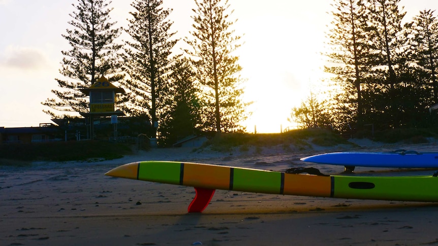 surfboards on a beach during sunset