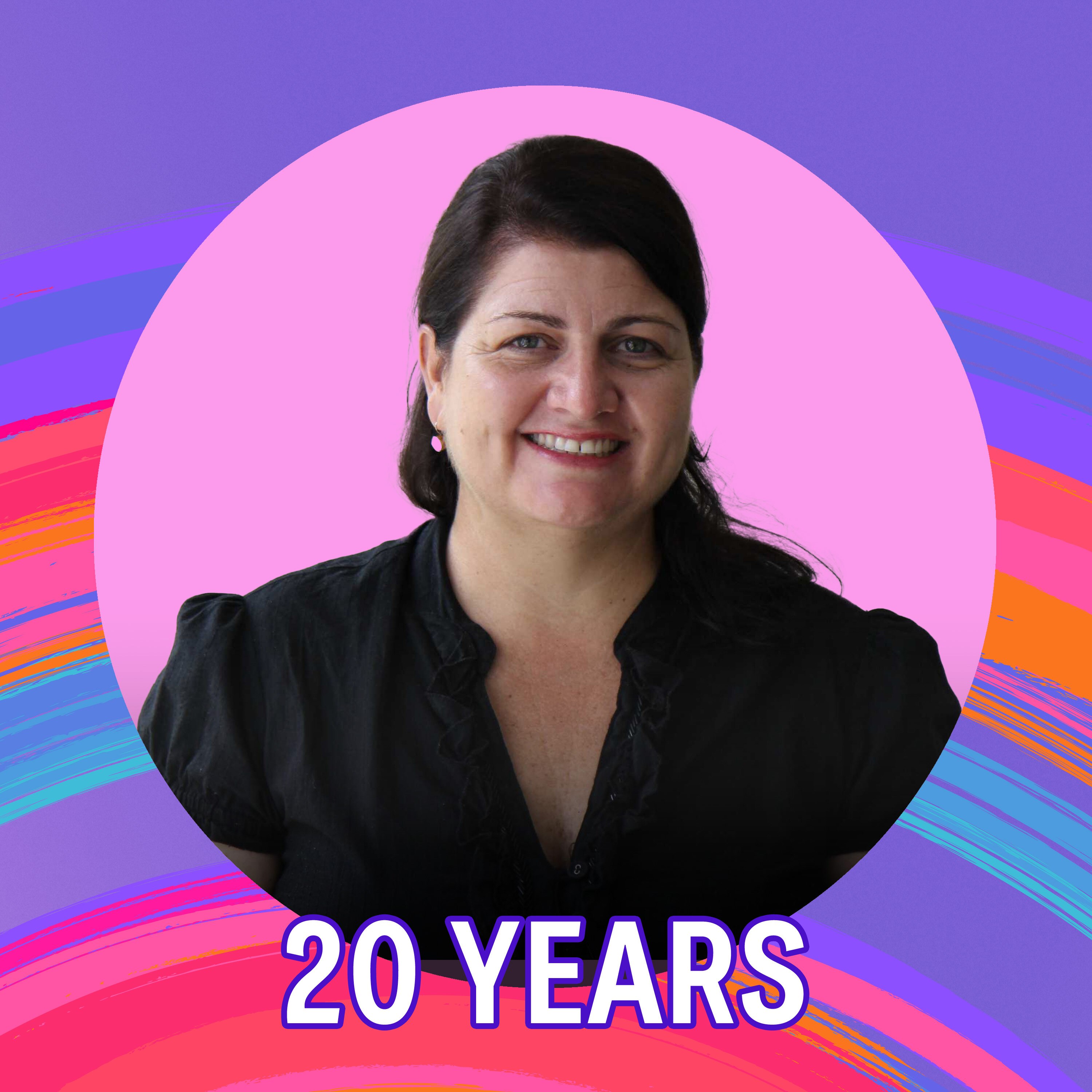 A woman wearing a black dress smiles.