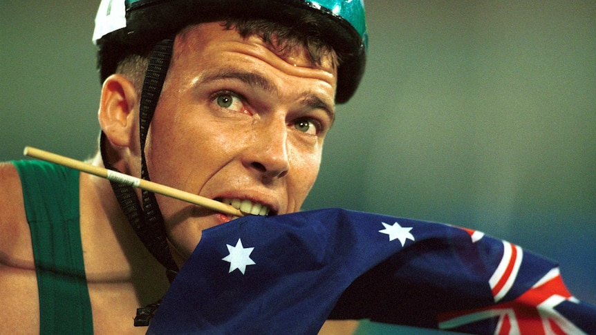 Paralympian Kurt Fearnley holds the Australian flag