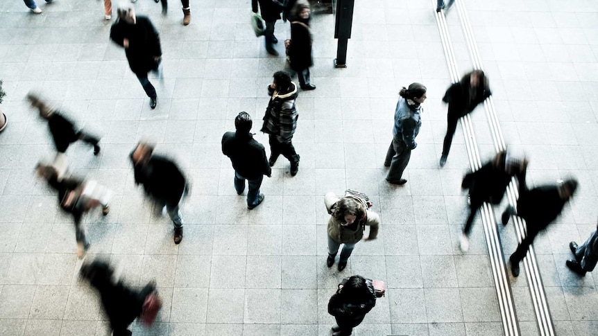 View from above of people moving around on a station platform