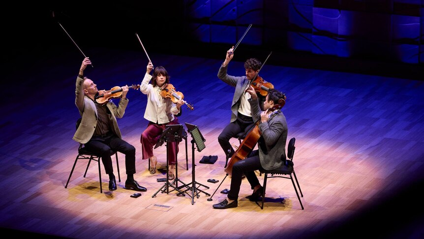 The Australian String Quartet finishing a performance at the Melbourne Recital Centre with a flourish, holding their bows up.
