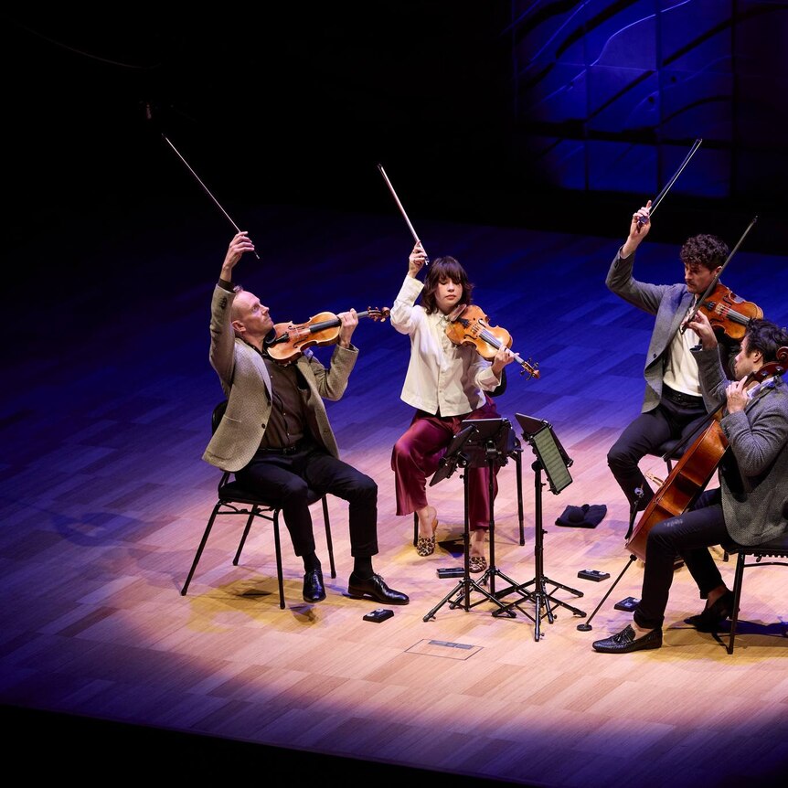 The Australian String Quartet finishing a performance at the Melbourne Recital Centre with a flourish, holding their bows up.