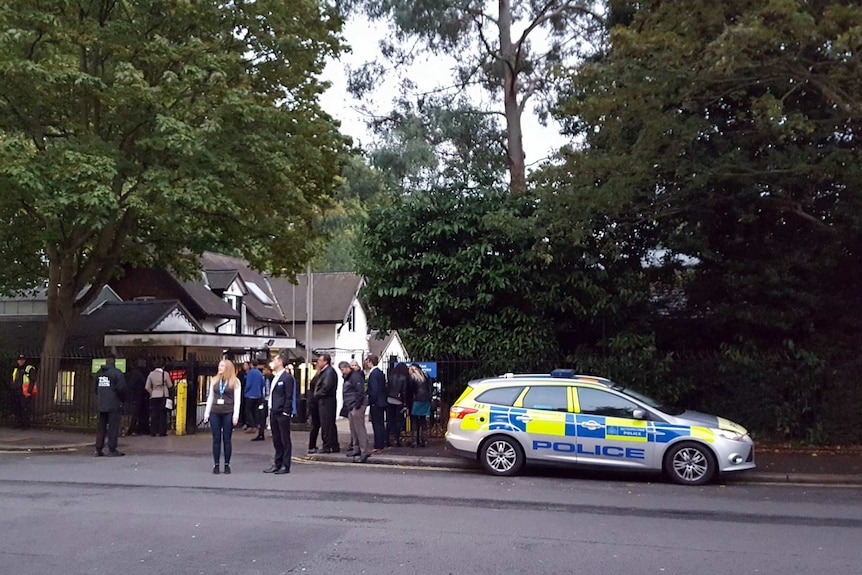 Police and evacuated visitors stand outside London Zoo after a gorilla escaped in London, Thursday, Oct. 13.