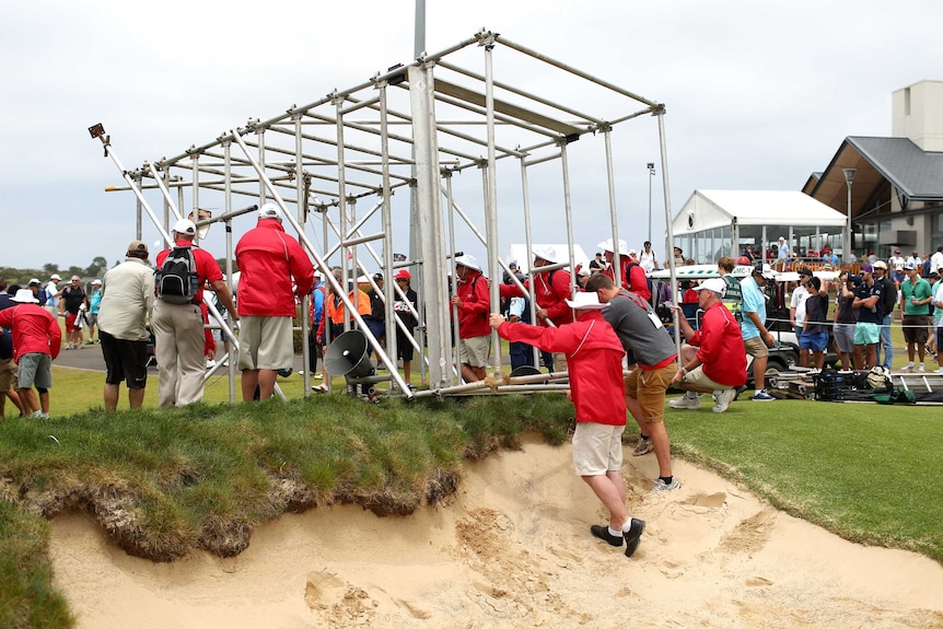 Blown over ... a TV tower comes off second best against the high winds at The Lakes course in Sydney.