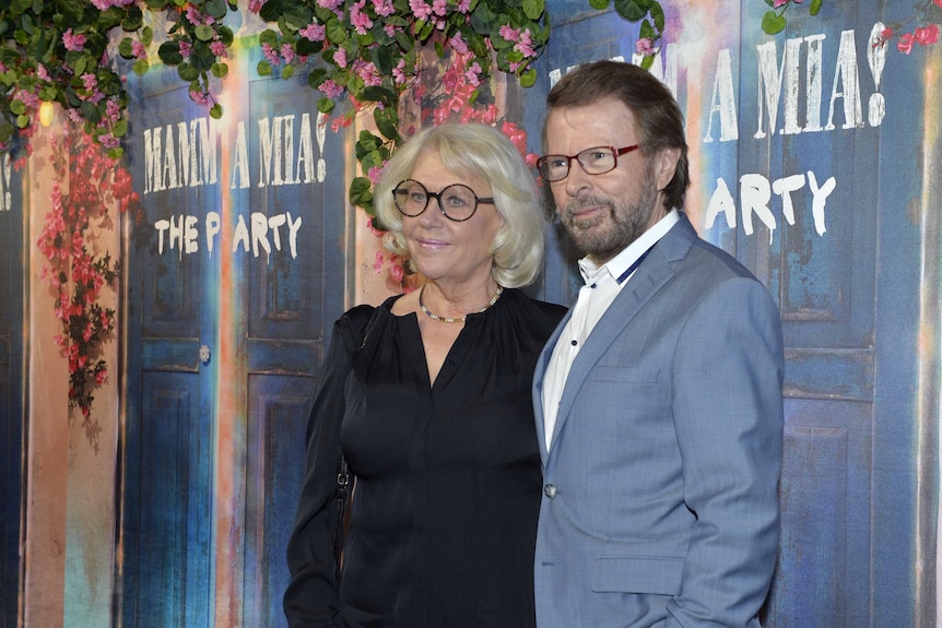 ABBA's  Bjorn Ulvaeus stands with wife Lena Kallersjo against Mamma Mia flowered backdrop