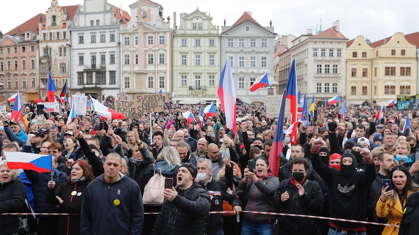 Demonstrators wave Czech flags and shout, many not wearing masks, at a protest against coronavirus measures in Prague.