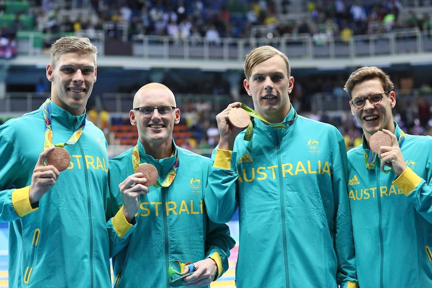 Men's medley relay team pose with their bronze medals