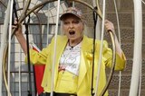 Fashion designer Vivienne Westwood sits suspended in a giant bird cage in protest