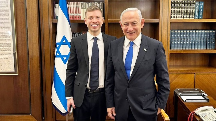 Benjamin Netanyahu posing with a young man in his office 