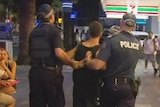 Man taken away by police at Schoolies