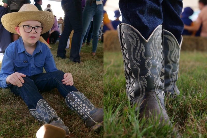 Jack wearing a hat, blue shirt and his brown, black and white boots, close up of boots on the right.