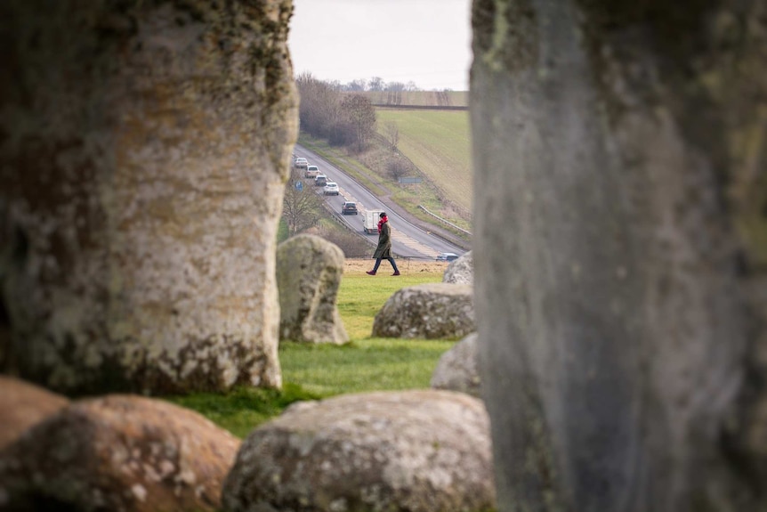A tourist walks past Stonehenge.