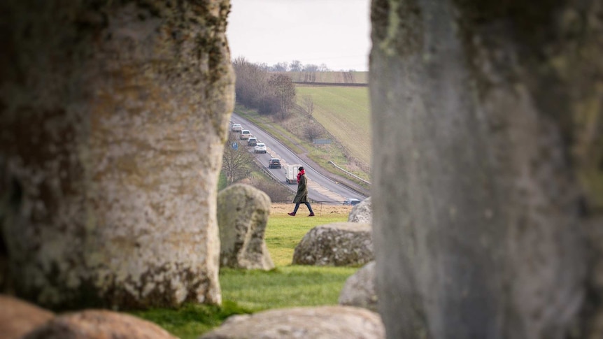A tourist walks past Stonehenge.